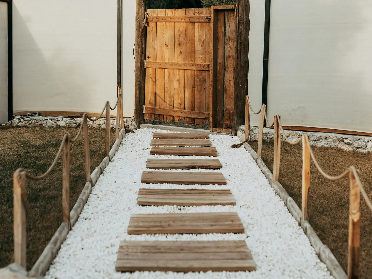 Camino de baldosas rectangulares de madera hacia la puerta de una casa